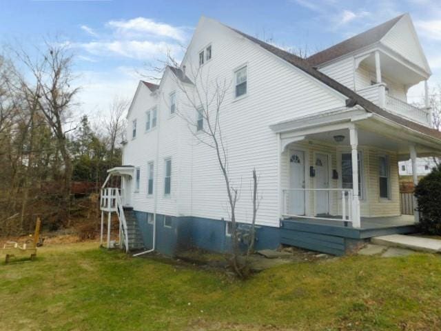 view of property exterior featuring a yard and a porch