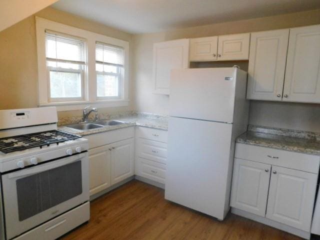 kitchen featuring white cabinetry, sink, wood-type flooring, and white appliances