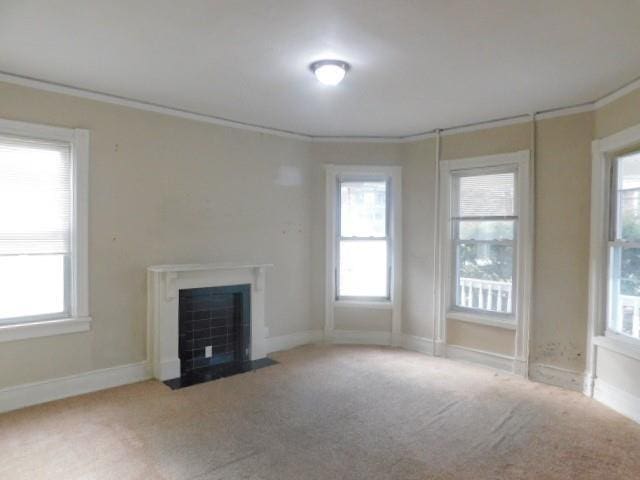 unfurnished living room featuring ornamental molding, carpet floors, and a healthy amount of sunlight