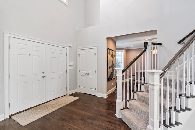 foyer with dark wood-type flooring and ornamental molding