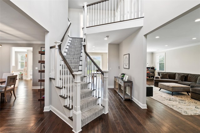 stairs with wood-type flooring and crown molding