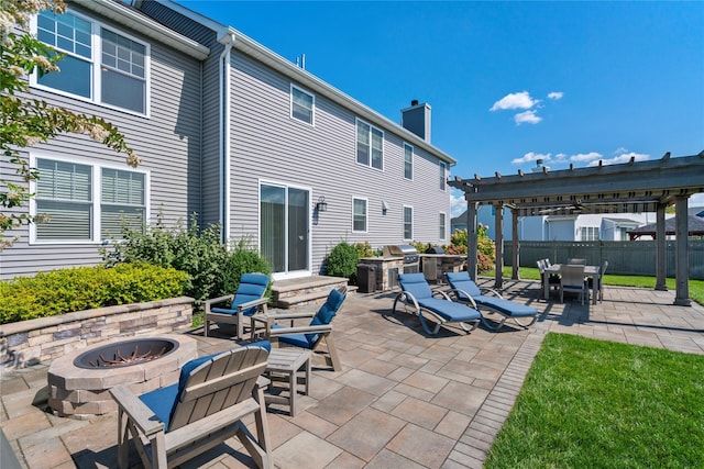 view of patio / terrace featuring a pergola, an outdoor fire pit, a grill, and exterior kitchen