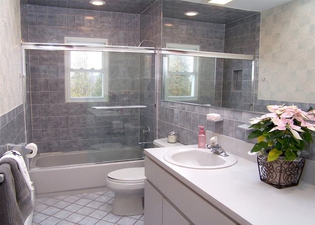 full bathroom featuring tile patterned flooring, vanity, tile walls, and enclosed tub / shower combo