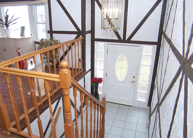 foyer with tile patterned floors and a notable chandelier