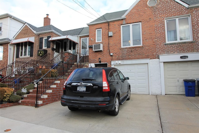 view of front of property with an AC wall unit and a garage