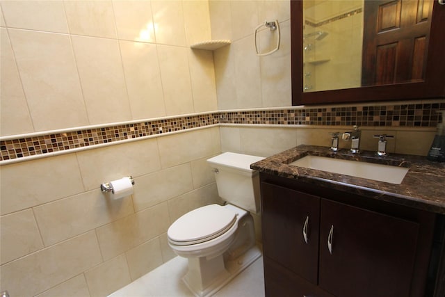 bathroom with vanity, toilet, tile walls, and backsplash