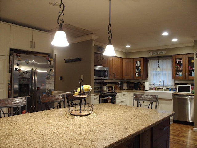 kitchen featuring light stone countertops, pendant lighting, and appliances with stainless steel finishes