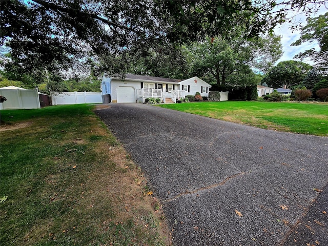 single story home featuring a porch, a garage, and a front lawn