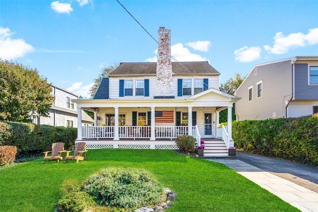 view of front of house featuring a porch, roof with shingles, and a front yard