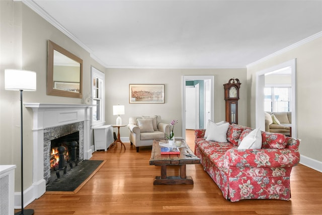 living area with crown molding, baseboards, wood finished floors, and a high end fireplace