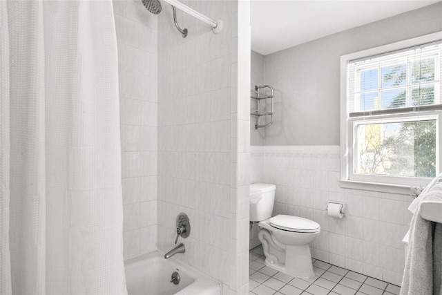 bathroom featuring shower / bath combo, wainscoting, toilet, tile patterned floors, and tile walls