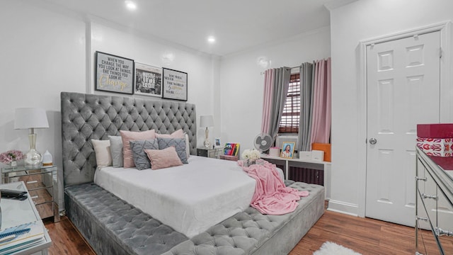 bedroom with crown molding and dark hardwood / wood-style floors