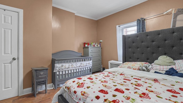 bedroom with hardwood / wood-style floors and crown molding