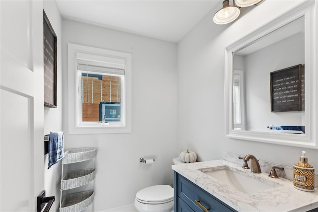 bathroom featuring vanity, heating unit, and toilet