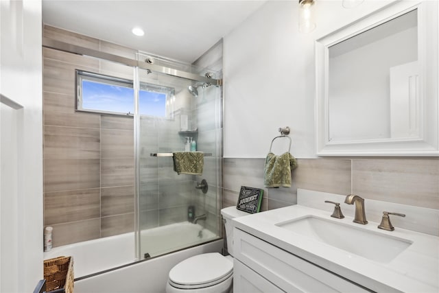 full bathroom with shower / bath combination with glass door, vanity, tasteful backsplash, and toilet