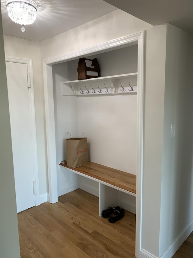 mudroom with a chandelier and wood-type flooring