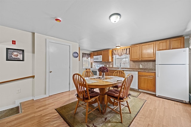 dining space with sink and light wood-type flooring