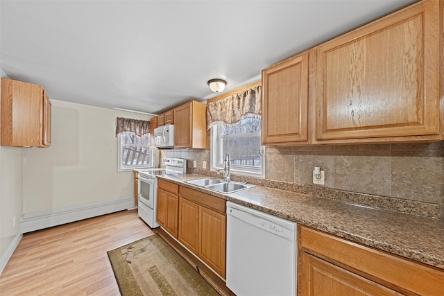 kitchen with light hardwood / wood-style floors, white appliances, sink, and tasteful backsplash