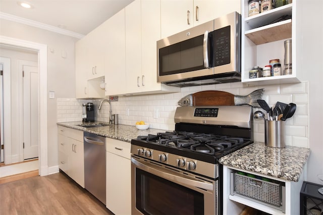 kitchen featuring stone counters, appliances with stainless steel finishes, white cabinetry, and sink