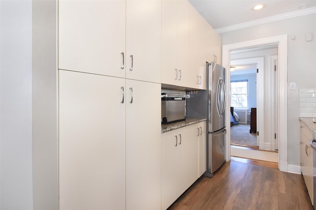 kitchen featuring stainless steel fridge, tasteful backsplash, light stone counters, dark hardwood / wood-style floors, and white cabinetry