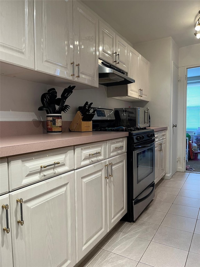 kitchen featuring light tile patterned floors, white cabinetry, and stainless steel range with gas cooktop