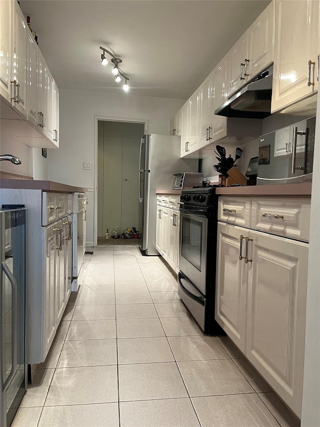 kitchen with dishwasher, light tile patterned floors, stainless steel fridge, stove, and white cabinets