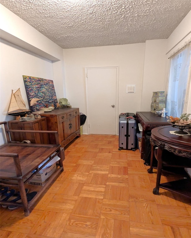 miscellaneous room featuring a textured ceiling and light parquet flooring