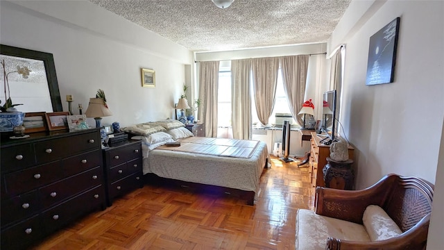 bedroom featuring a textured ceiling and parquet floors