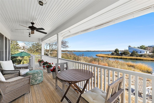 wooden deck featuring ceiling fan and a water view