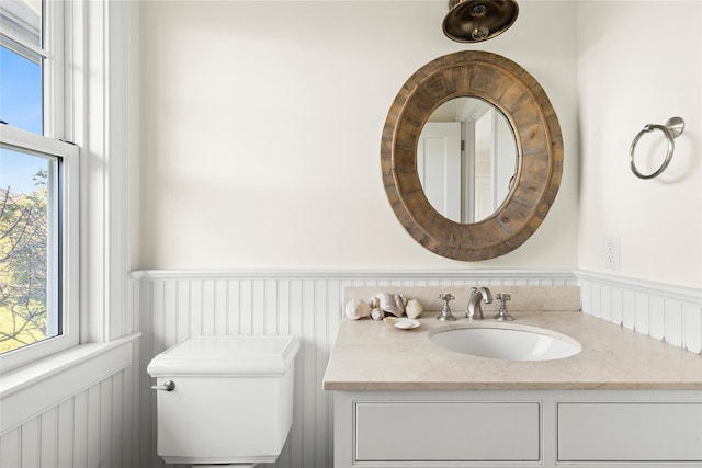 bathroom featuring plenty of natural light, toilet, and vanity