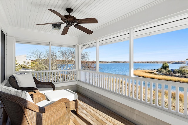 sunroom featuring ceiling fan, plenty of natural light, a water view, and wood ceiling