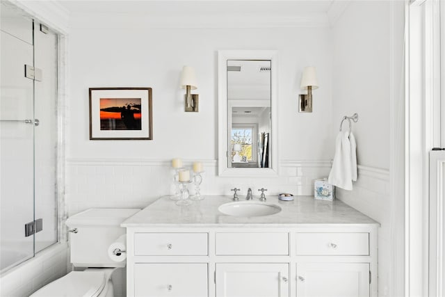 full bathroom with crown molding, vanity, bath / shower combo with glass door, and toilet