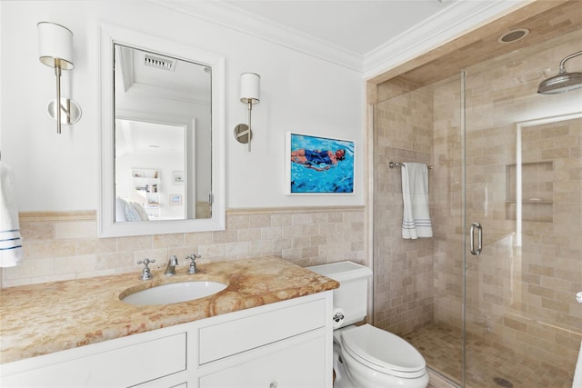 bathroom with walk in shower, crown molding, toilet, vanity, and tile walls