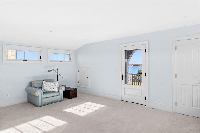 sitting room featuring light carpet, a water view, and vaulted ceiling