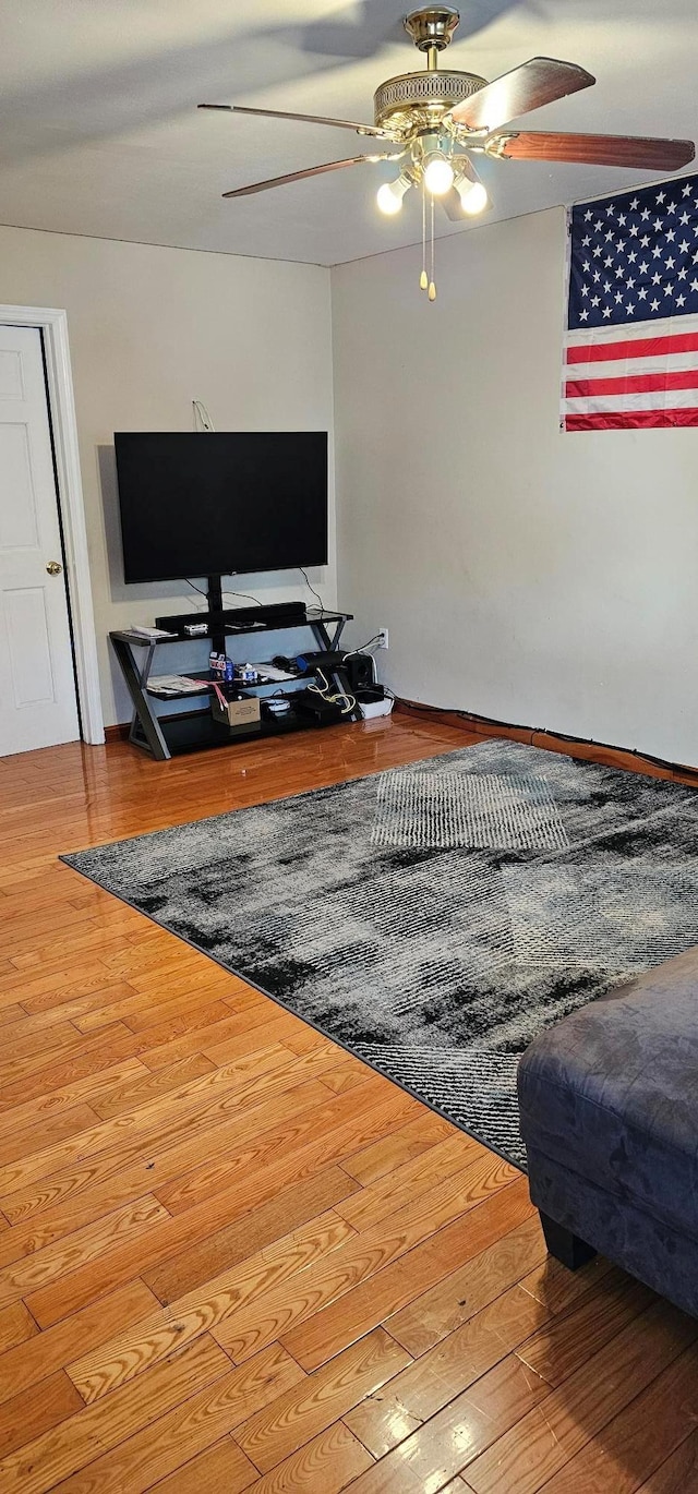 living room featuring hardwood / wood-style floors and ceiling fan