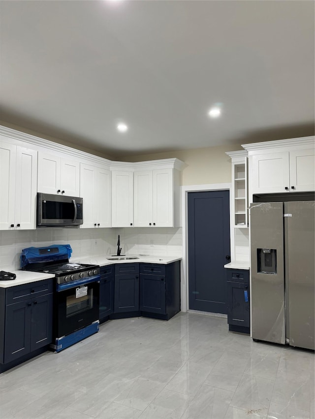 kitchen with white cabinets, appliances with stainless steel finishes, decorative backsplash, and sink
