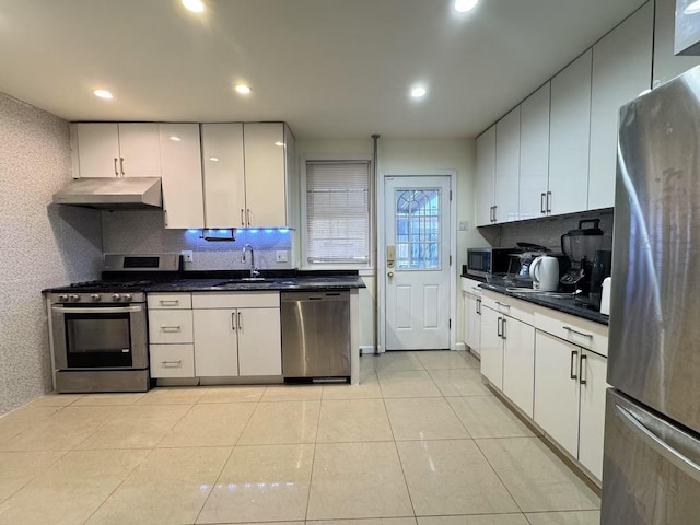 kitchen with backsplash, white cabinetry, appliances with stainless steel finishes, light tile patterned flooring, and sink