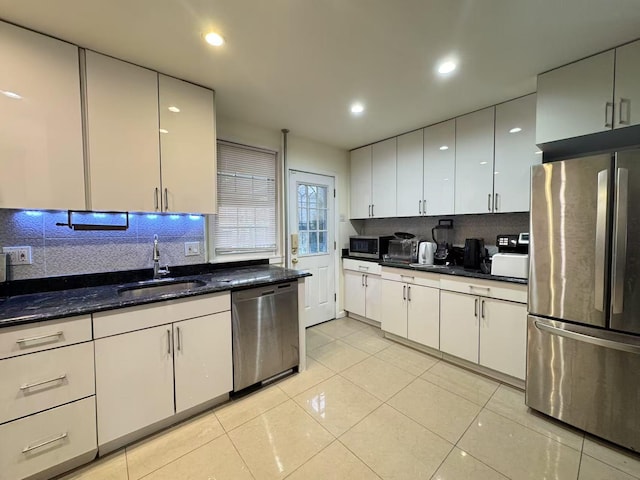 kitchen featuring stainless steel appliances, light tile patterned floors, sink, and tasteful backsplash