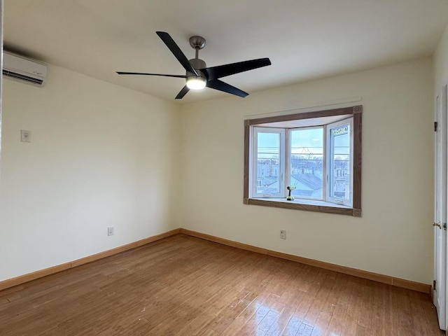 empty room with hardwood / wood-style flooring, a wall mounted AC, and ceiling fan