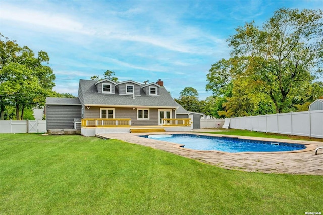 rear view of property with a lawn and a pool side deck