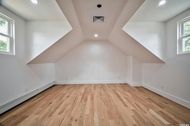 bonus room featuring lofted ceiling, light hardwood / wood-style flooring, and a baseboard radiator