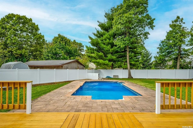 view of swimming pool with a yard, a patio, and a deck