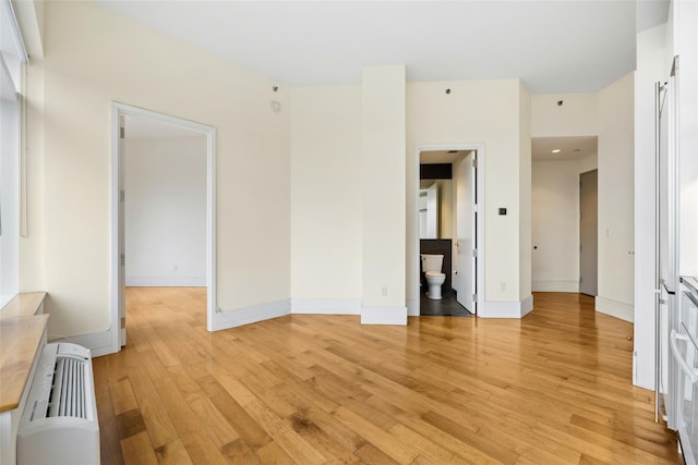 unfurnished room with light wood-type flooring and radiator