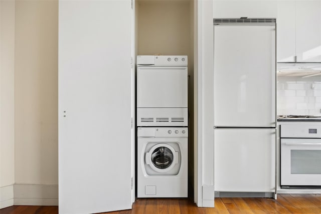 washroom featuring wood-type flooring and stacked washing maching and dryer