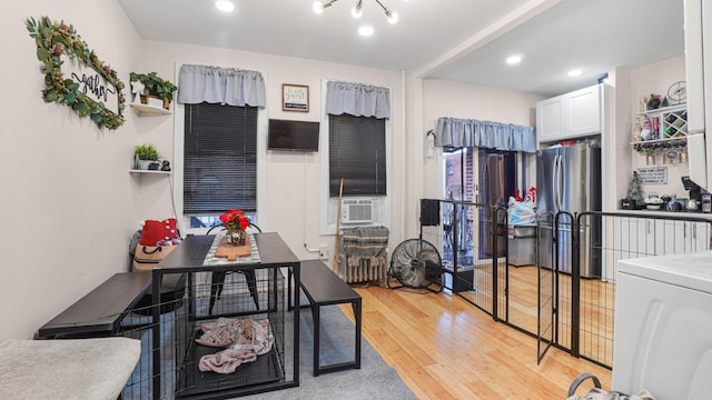 kitchen with white cabinets, cooling unit, light hardwood / wood-style flooring, stainless steel refrigerator, and washer / clothes dryer