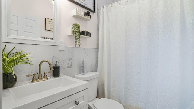 bathroom featuring backsplash, vanity, tile walls, and toilet