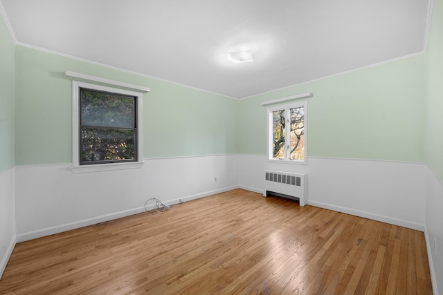 unfurnished room with radiator heating unit and light hardwood / wood-style flooring