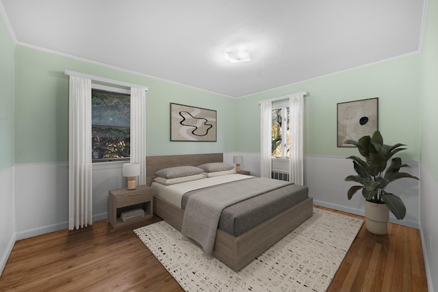 bedroom with crown molding and hardwood / wood-style floors