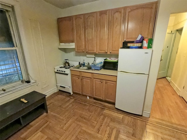 kitchen featuring white appliances and light parquet floors