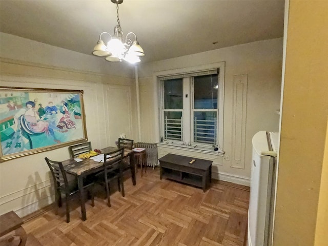 dining area with parquet flooring and an inviting chandelier